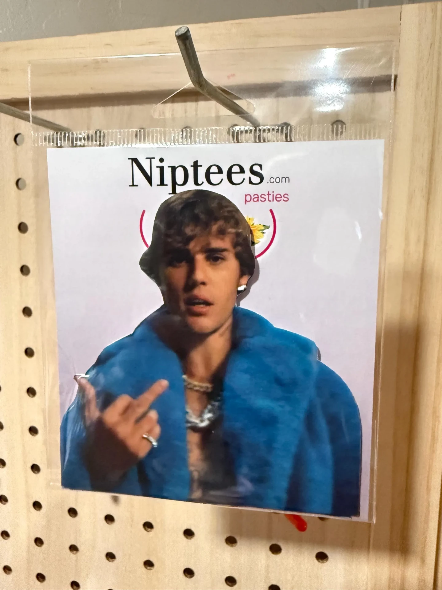 Custom face pastie of a pop star in a blue jacket, in Niptees packaging